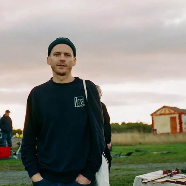 Portrait of Digital Designer Jonny Rich wearing a beanie at a car boot sale in Wales, United Kingdom. Shot on a Nikon FM2n 35mm film camera.